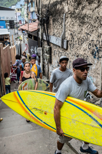 José Ricardo "Bocão" seguido pelos alunos da Rocinha Surfe Escola.